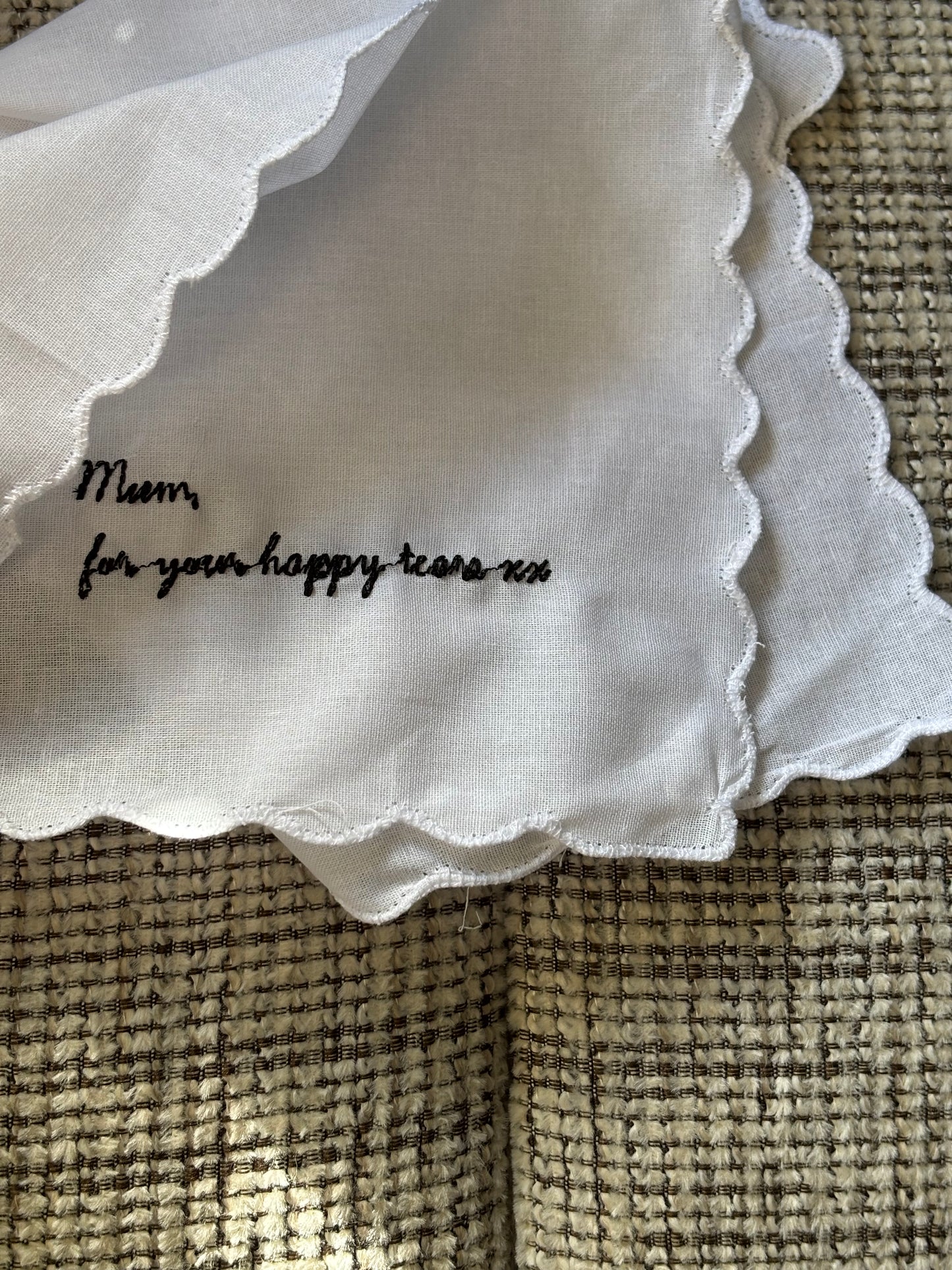 White fabric with text on a textured beige surface
